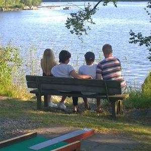 Familj på bänk vid sjön
