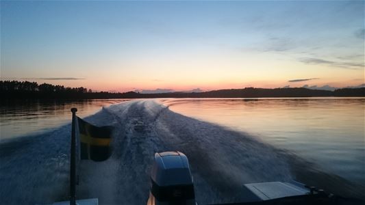 Akter på båt med svenska flaggan ute på sjön. 
