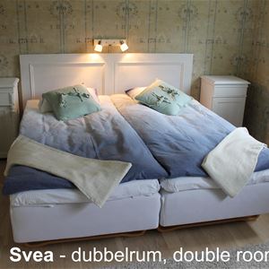 Rum med dubbelsäng och två sängbord.
