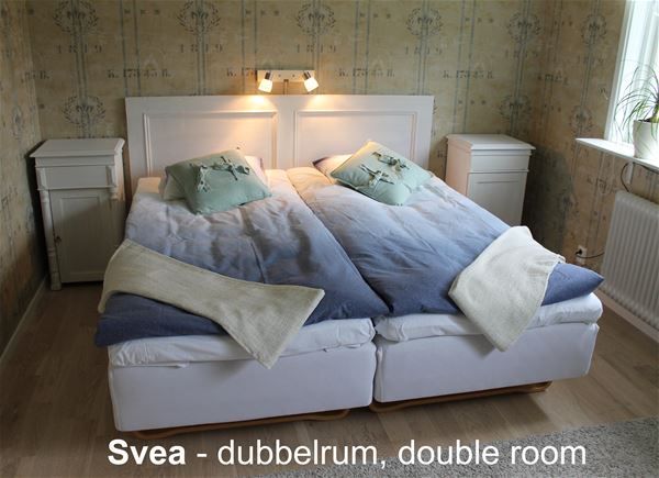 Rum med dubbelsäng och två sängbord. 