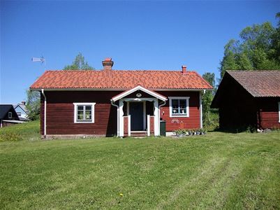 Red log cabin with white window linings.