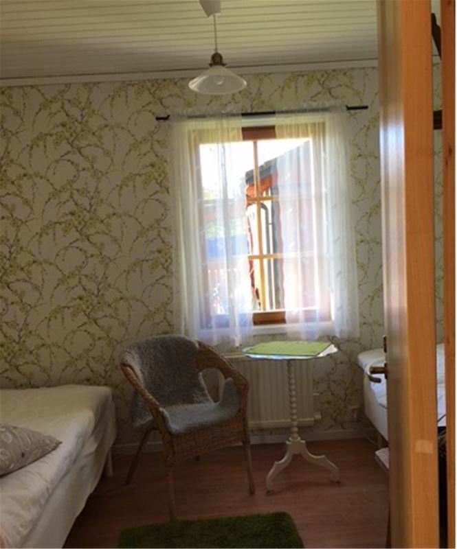 Bedroom with two single beds and patterned wallpaper. 