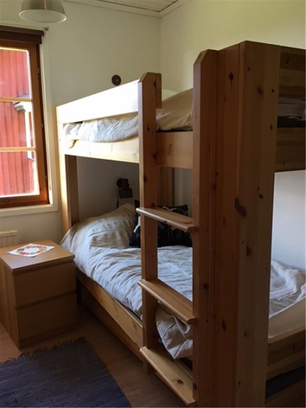 Bunkbed in a bedroom with white walls.