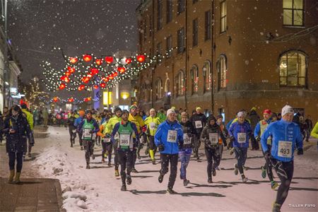 Deltakere løper gjennom byen mens det snør
