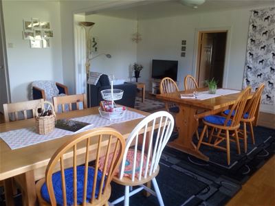 Dining area with two tables and eights chairs in total.