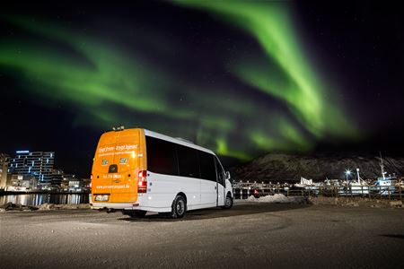 Photo of the tour's minibus in front of the Northern Lights