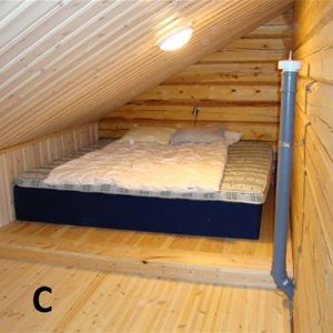Stor madrass på golvet i rum med lutande tak på loftet.