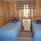 Två enkelsängar i ett rum med väggar av furu. 