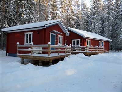 Two timber cottaged covered in snow.