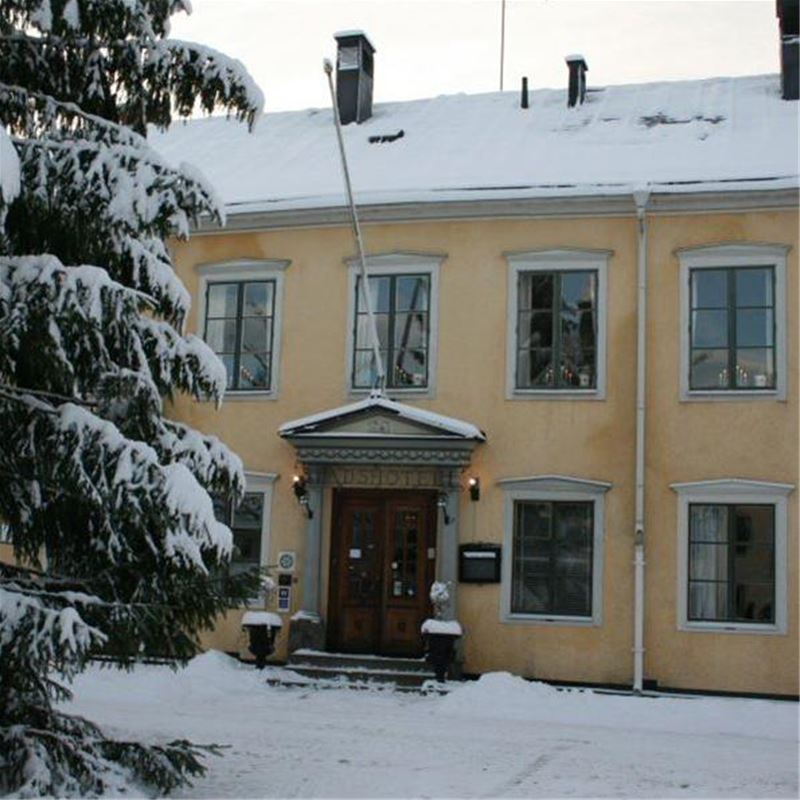 Large yellow hotel building on a winter day.