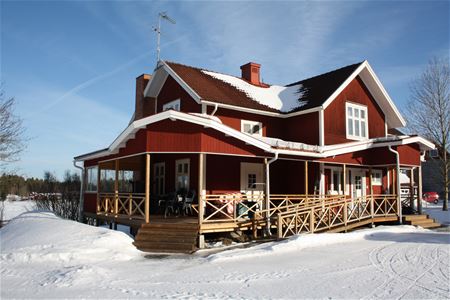 Red painted house with a large veranda.