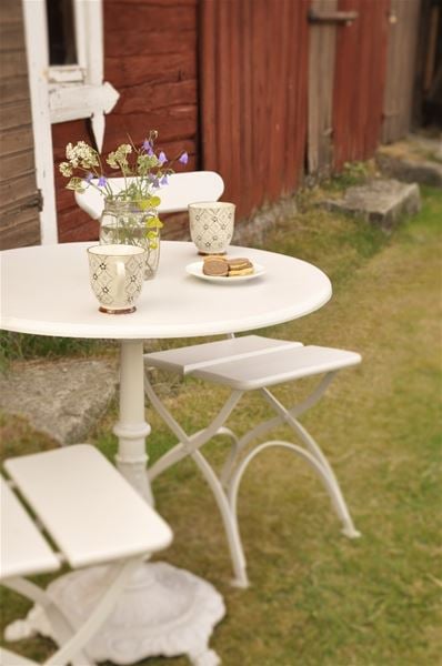 A small table and two chairs in the garden. 