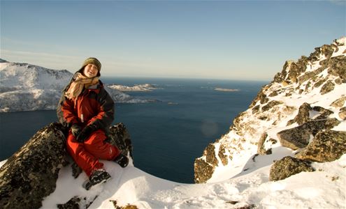 Guest posing on top of a mountain