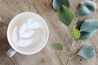 Kaffekopp med bladmønster i melken