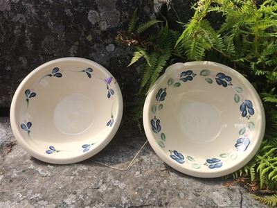 Two white glazed ceramic dishes with floral patterns.