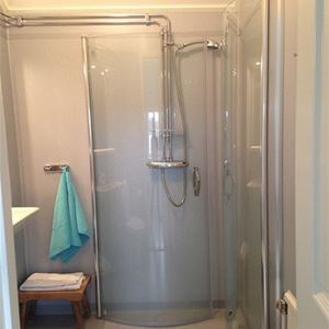 Badrum med duschkabin med glasdörrar.