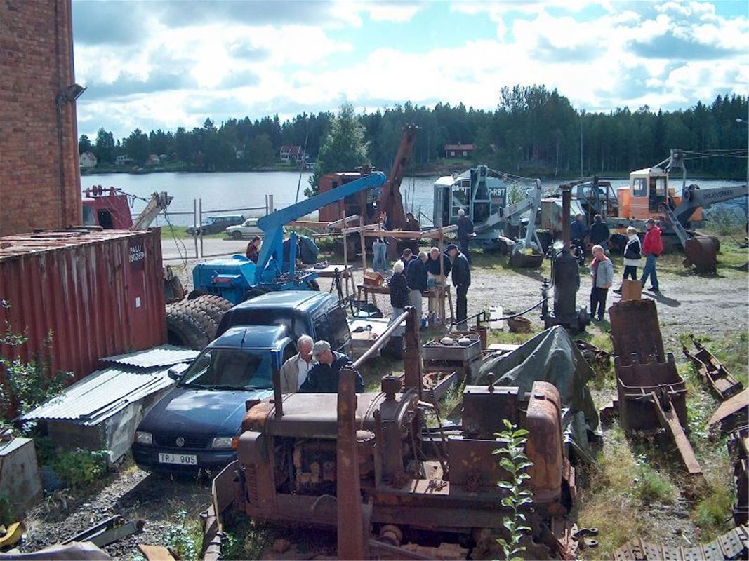 several old vehicles in a backyard of the museum.