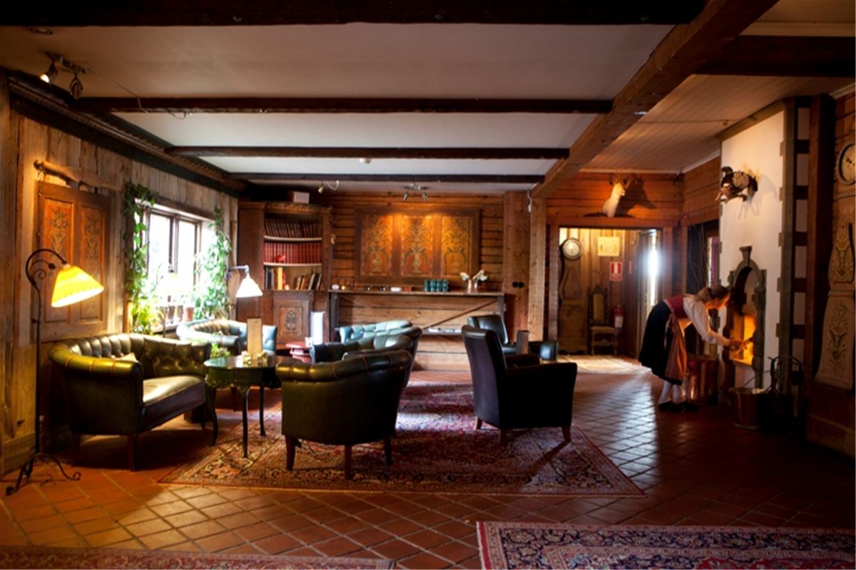 Lounge with leather sofas and dalecarlian paintings on the walls. 