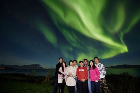 Group of guests under the northern lights