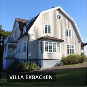 Villa Ekbacken med tvåvåningshus med ljus panel och brutet tak. 