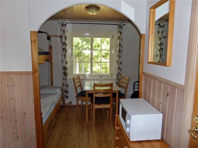 Rum med våningssäng och ett matbord med tre stolar.