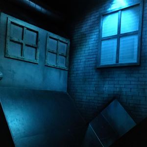 Ett mörkt rum i prison island med låtsas fönster på väggarna.