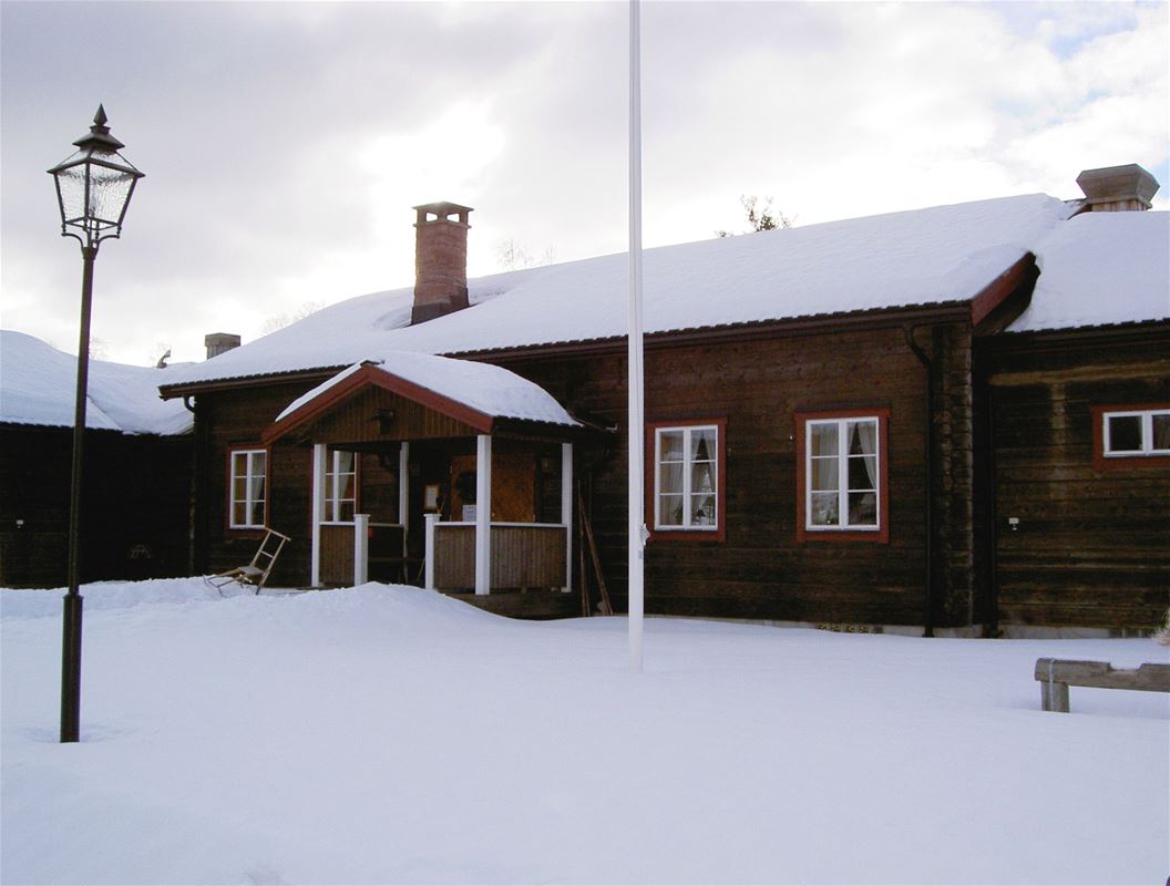 Timmerhus med snö på taket.