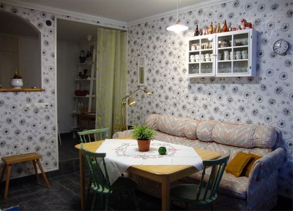 Matplats i kök med tre stolar och en soffa. 