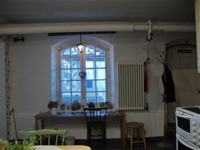 Barred basement window with rounded top.