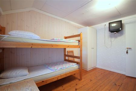 Rum med våningssäng och tv på väggen.