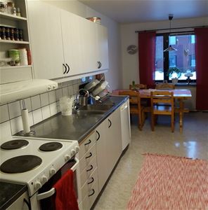 White kitchen with dining furniture in pine in front of the window.