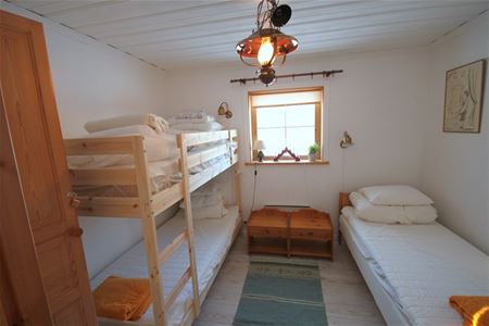 Sovrum med en våningssäng och en säng.