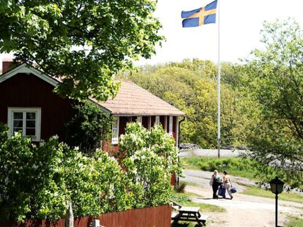 Idylliskt trähus och svenska flaggan 