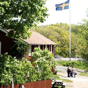 Idylliskt trähus och svenska flaggan