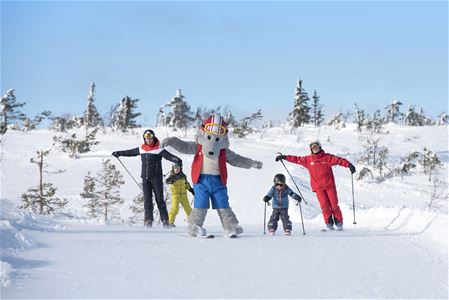 Barn åker skidor utför.