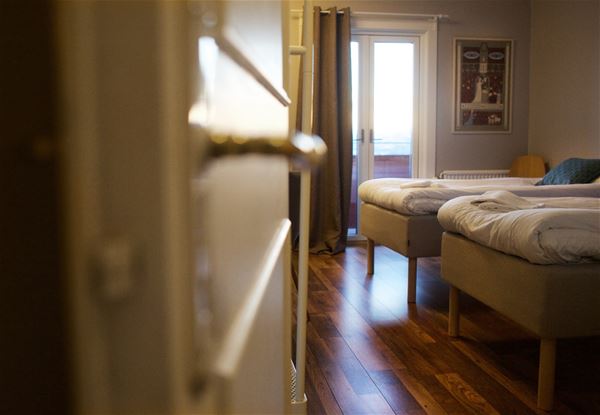 Open door to a room with two single beds.  