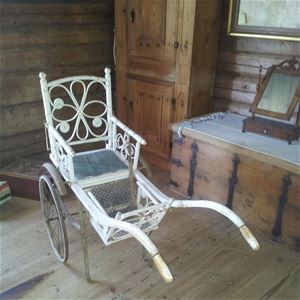 Interior image from one of the buildings, a white oldfashioned wheelchair.