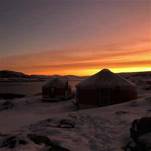 fint solnedgang over yurt med oransje himmel