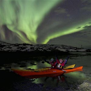 To personer i kajakk under nordlyset