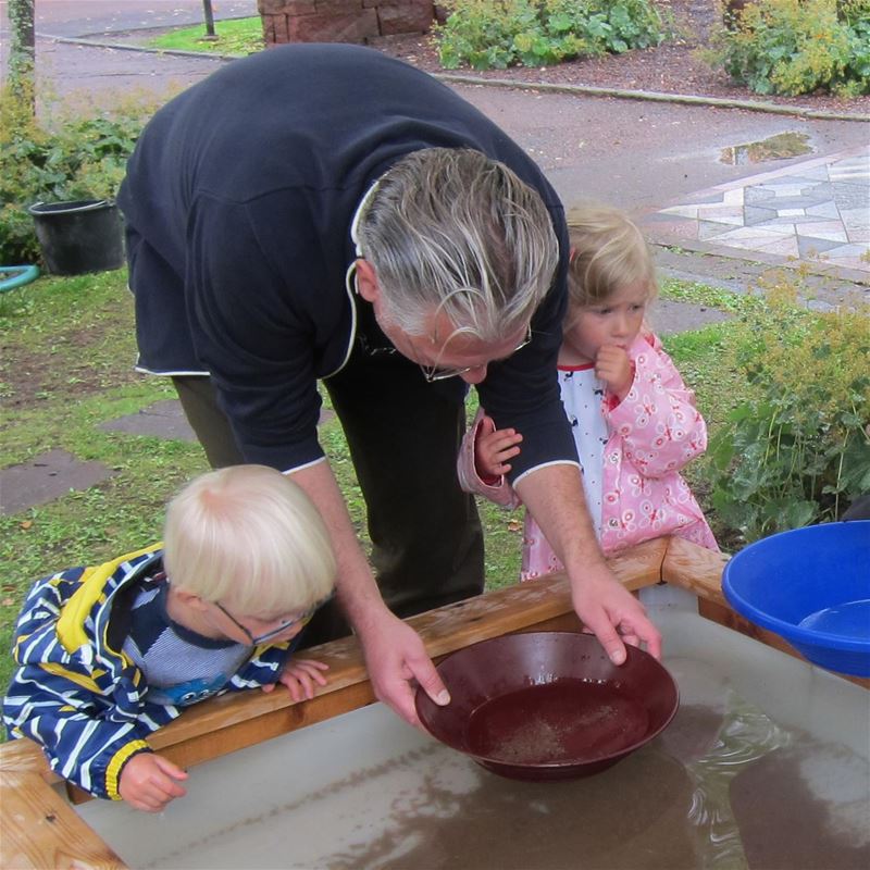 A man and two children doing gold washing.