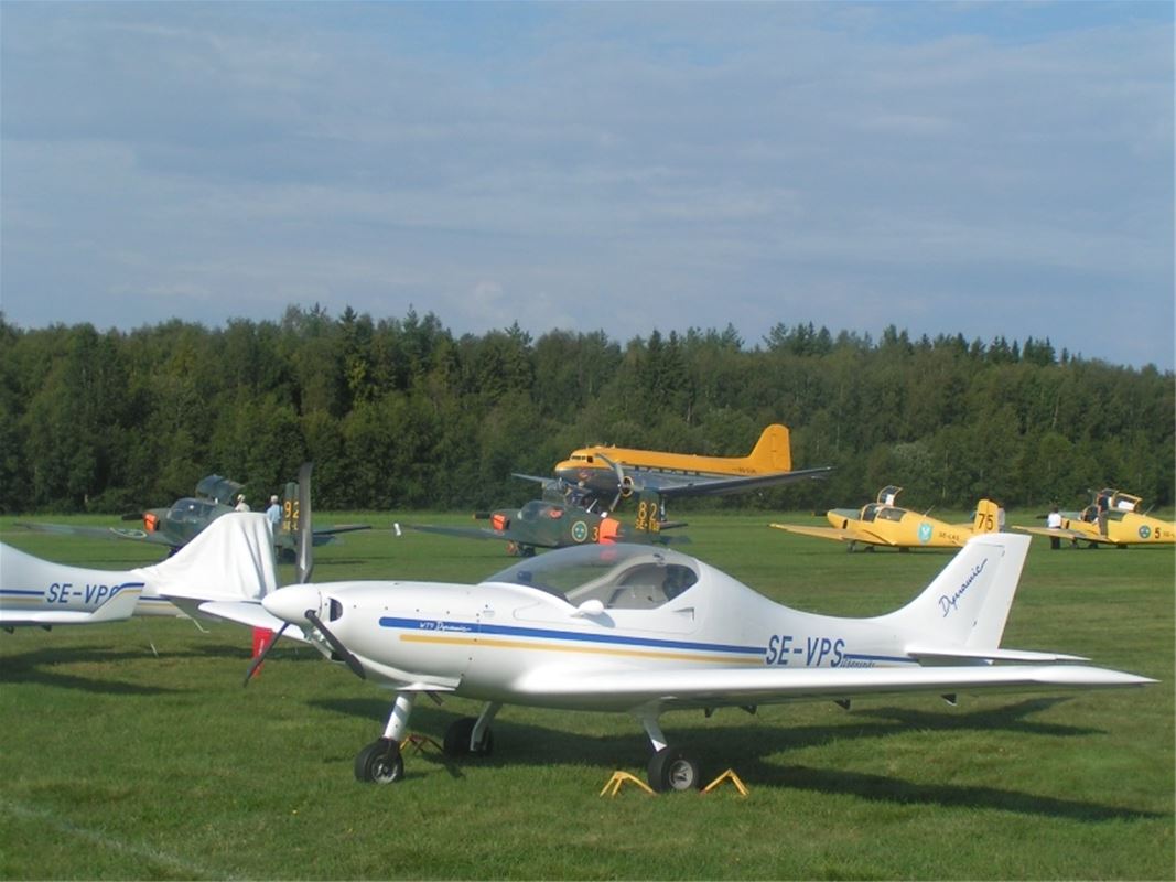 Flygplan som står på fältet.