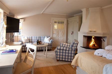 A suite with a double bed and a fire place.