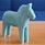 Ljusblå dalahäst på ett bord.