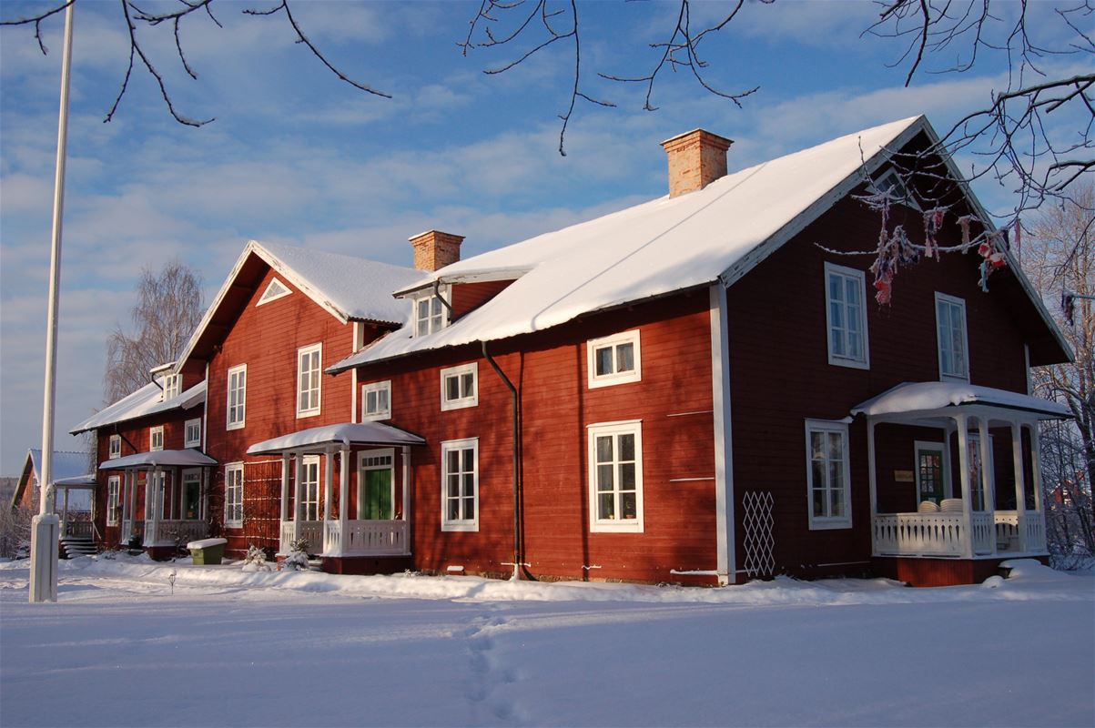 Rött hus i vinterlandskap.