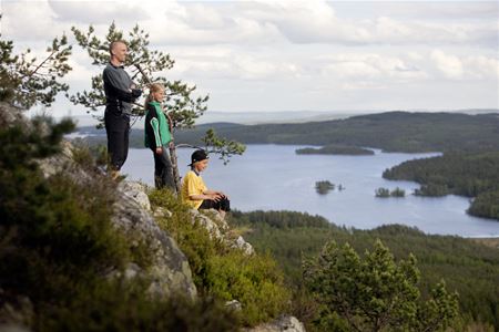 Utsikt från Ärtknubben, en man och två barn som tittar ut över landskapet.