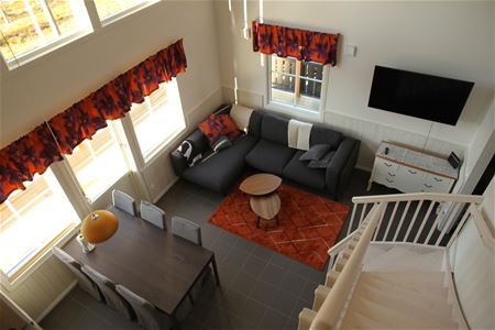 Storstuga med soffa, tv och matgrupp.
