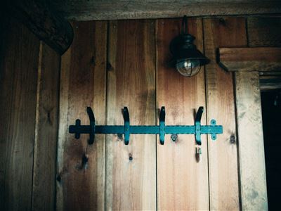 Gray board wall with coat hanger in black wrought iron.