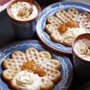 Waffles with cloudberry jam and cream on dalecarlian plates. 