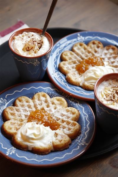 Waffles with cloudberry jam and cream on dalecarlian plates.  