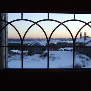 Utsikt över Fryksås genom ett blyinfattat fönster.